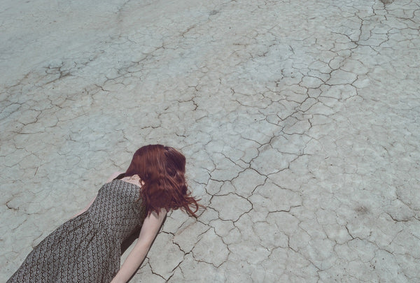 woman laying on dry ground