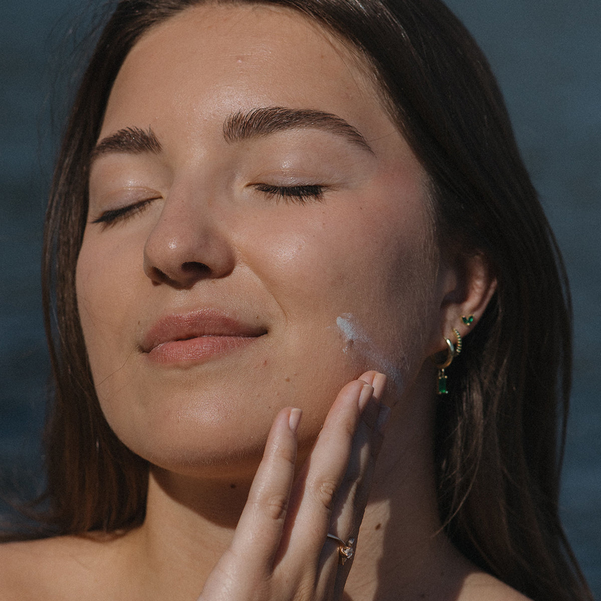 Women applying NENA 100% Mineral Sunscreen to her face